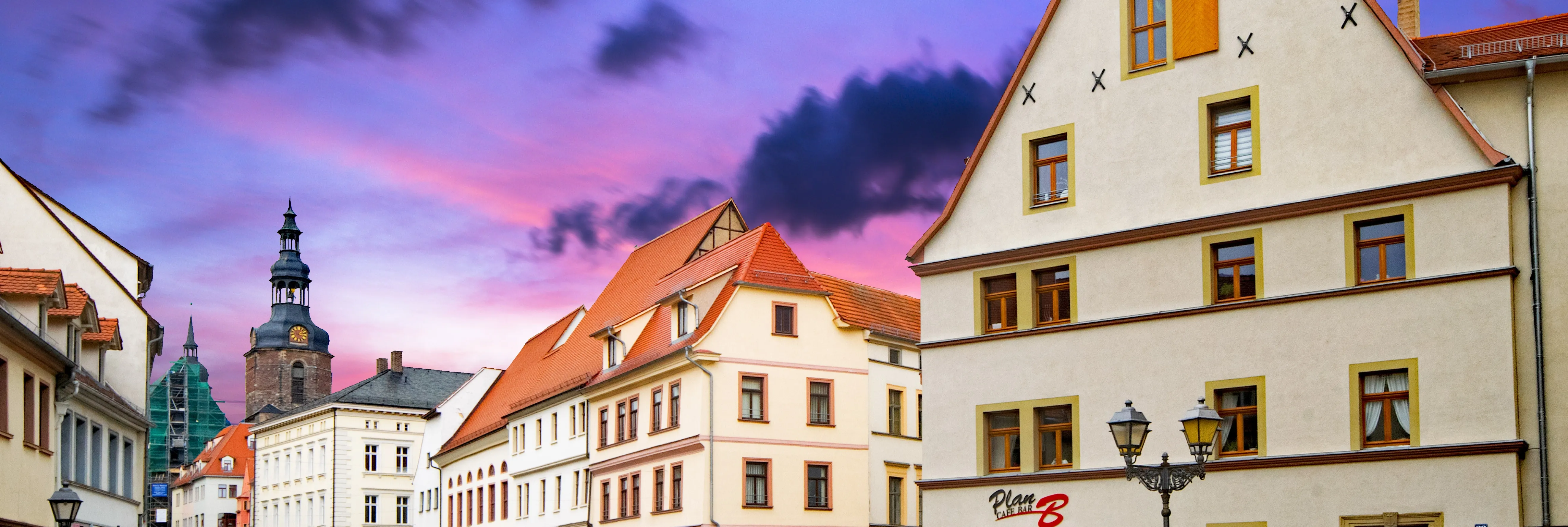 Innenstadt von Eisleben: Mehrere Gebäude sind zu sehen, sowie ein Kirchturm im Hintergrund