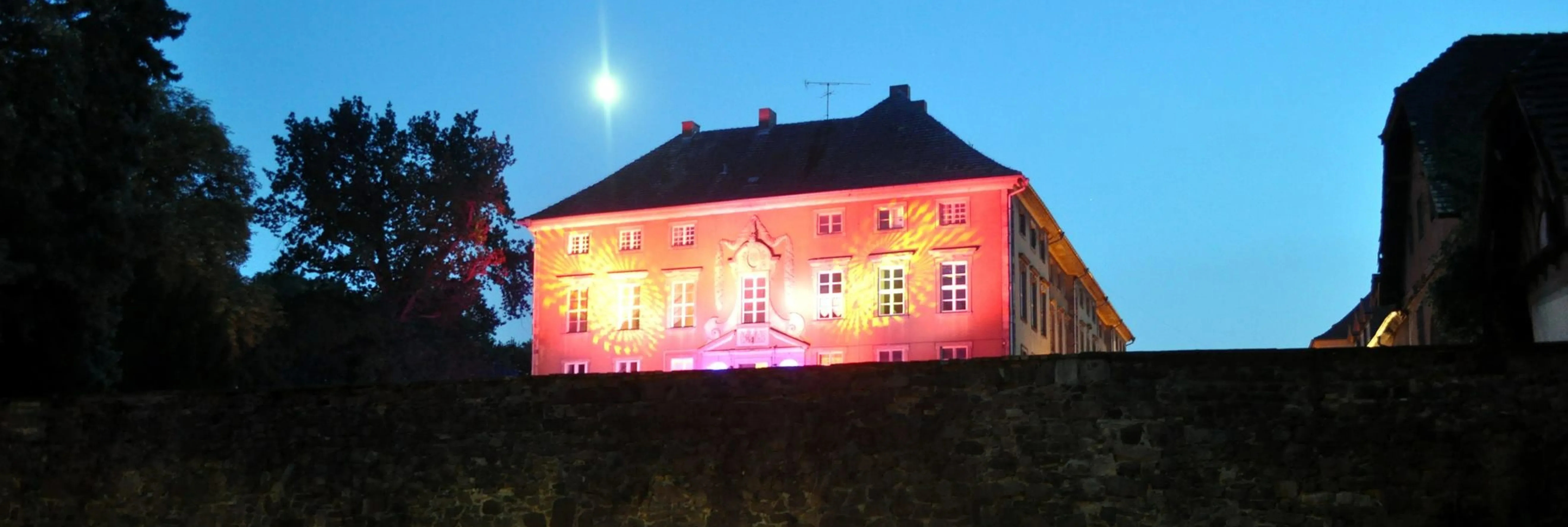 Schloss Ostrau Schloss Ostra: Ein beleuchtetes Gebäude im Dunkeln